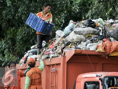 Pekerja Sudin Kebersihan Jagakarsa mengangut sampah dari mobil bak di TPS sementara, Jakarta, Senin (11/7). Pasca libur Lebaran, volume sampah di Kecamatan Jagakarsa diperkirakan mencapai 200 ton. (Liputan6.com/Yoppy Renato)