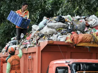 Pekerja Sudin Kebersihan Jagakarsa mengangut sampah dari mobil bak di TPS sementara, Jakarta, Senin (11/7). Pasca libur Lebaran, volume sampah di Kecamatan Jagakarsa diperkirakan mencapai 200 ton. (Liputan6.com/Yoppy Renato)