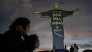 Patung Christ the Redeemer diterangi dengan pesan yang bertuliskan dalam bahasa Portugis; "Lebih dari 500 ribu jiwa dunia" yang mengacu pada korban meninggal karena Covid-19 di seluruh dunia, di Rio de Janeiro, Brasil, Rabu (1/7/2020). (AP Photo / Leo Correa)