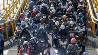 Pemudik bermotor antre untuk masuk ke kapal penumpang Feri menuju kampung halaman menjelang perayaan Idul Fitri di pelabuhan Gilimanuk Kabupaten Jembrana, Bali (01/06/2019) (Sonny Tumbelaka / AFP)