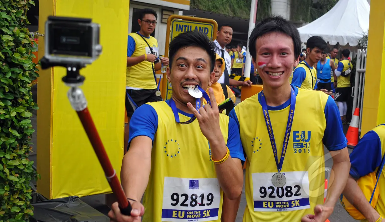 Peserta ber-selfie usai mengikuti lomba lari massal bertajuk 'EU On The Move 5K' di Sudirman, Jakarta, Minggu (3/5/2015). Acara lari tersebut memulai garis start di Sampoerna Strategic Square dan finish di Menara Intiland. (Liputan6.com/Yoppy Renato)