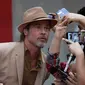 Aktor Brad Pitt berselfie dengan penggemar saat menghadiri acara karpet merah untuk film "Once Upon a Time In Hollywood" di Mexico City (12/8/2019). Film garapan sutrada Quentin Tarantino ini akan diputar di Mexico City pada Agustus 23.  (AP Photo/Marco Ugarte)