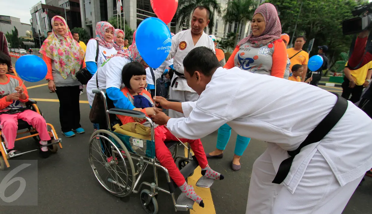 Seorang anak disabilitas mendapat balon saat mengikuti Jalan Sehat Keluarga Disabilitas (JSKD) di Pasar Akhir Pekan SCBD, Jakarta (11/12). (Liputan6.com/Fery Pradolo)