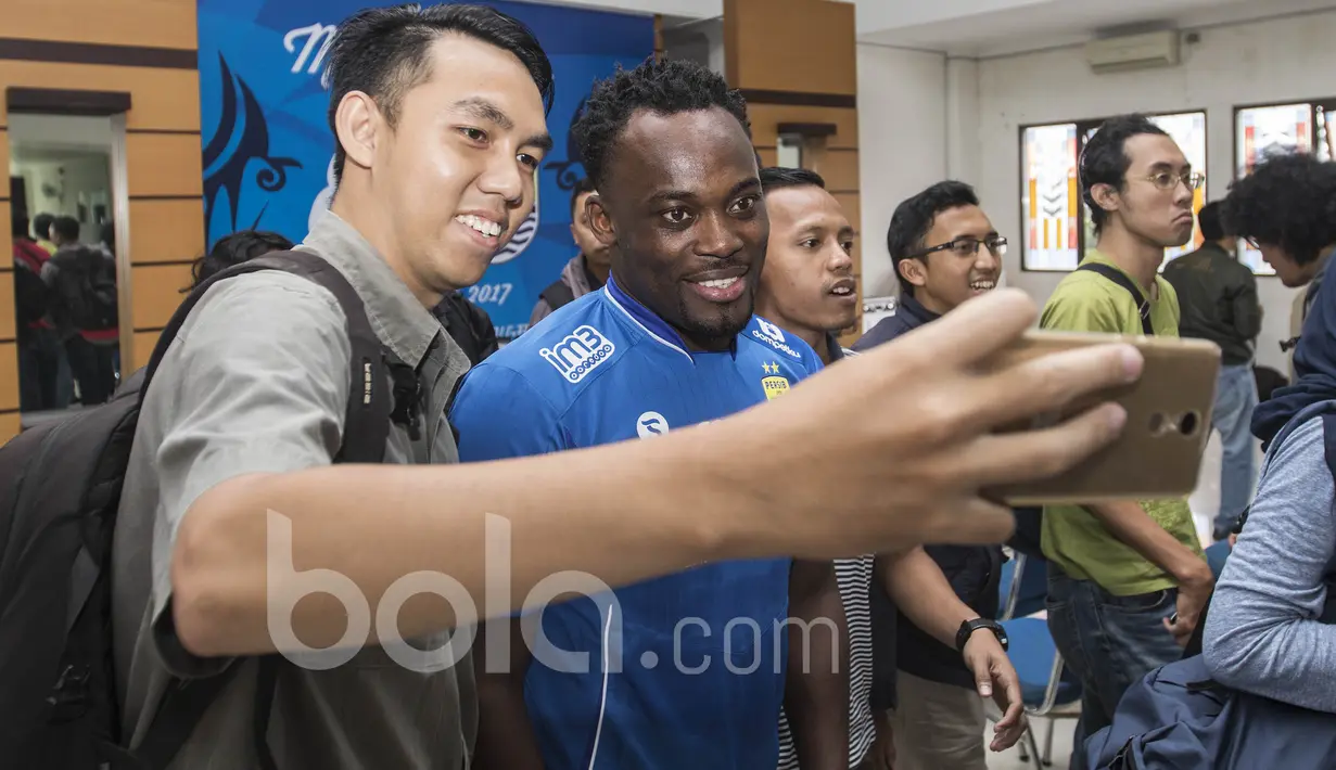 Bintang Persib Bandung, Michael Essien, melayani permintaan swafoto para wartawan. Meski baru tiba di Bandung dan langsung melakukan jumpa pers, mantan pemain Chelsea itu tetap ramah menyapa wartawan. (Bola.com/Vitalis Yogi Trisna)