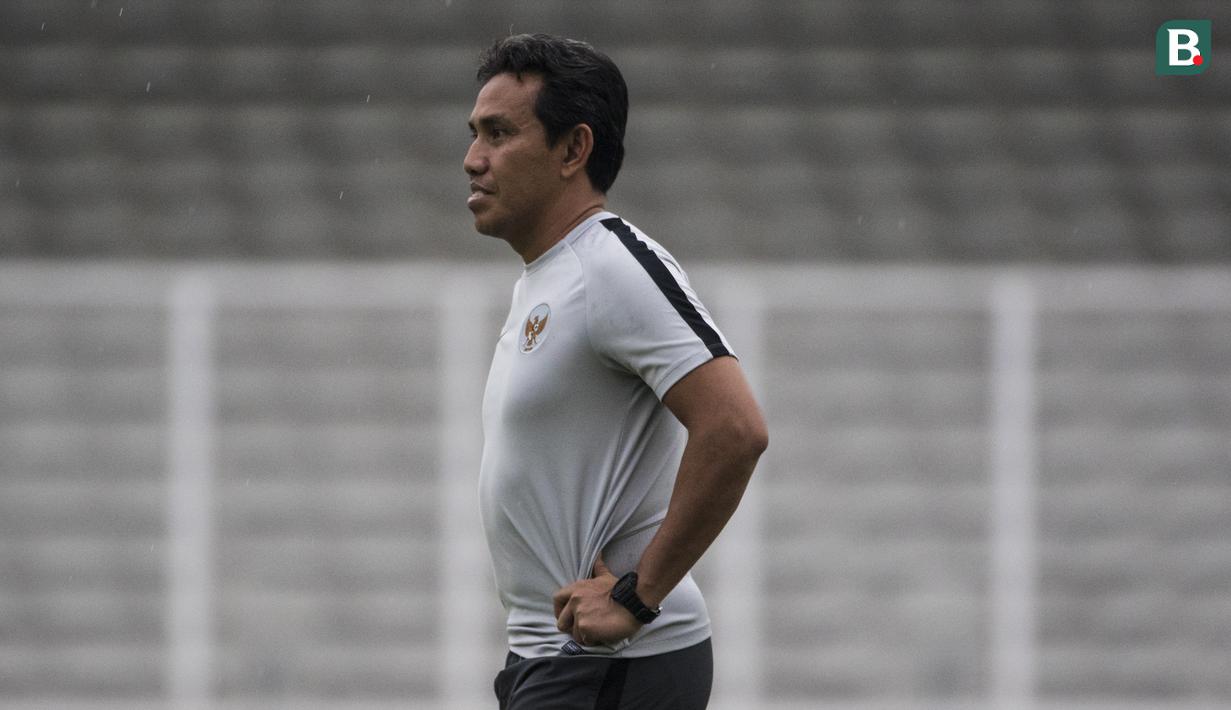 Pelatih Timnas Indonesia, Bima Sakti, mengamati anak asuhnya saat latihan di Stadion Madya, Jakarta, Minggu (11/11). Latihan ini persiapan jelang laga Piala AFF 2018 melawan Timor Leste. (Bola.com/Vitalis Yogi Trisna)