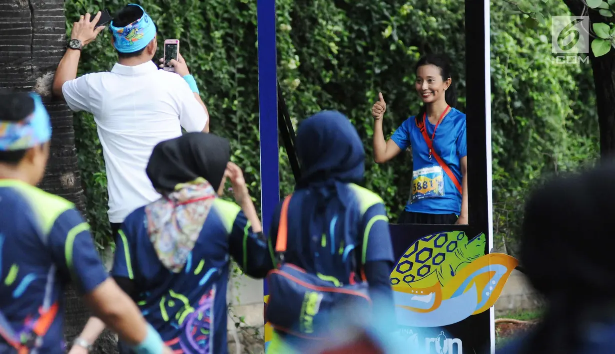 Pelari menyempatkan berfoto saat mengikuti lomba Pertamina Eco Run 2017 di Pantai Karnaval Ancol, Jakarta, Sabtu (16/12). Pertamina Eco Run 2017 diikuti ribuan pelari dari tiga kategori, yakni master, umum dan pelajar. (Liputan6.com/Helmi Fithriansyah)