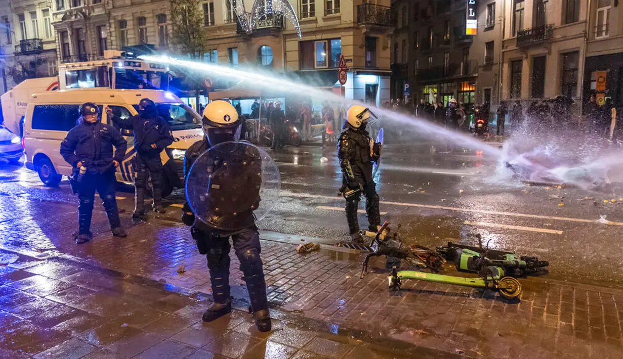 Polisi antihuru-hara berdiri di jalan utama di Brussel, Belgia, 27 November 2022. Polisi harus menutup sebagian pusat Kota Brussel dan bergerak dengan meriam air serta gas air mata untuk membubarkan massa menyusul kerusuhan selama dan setelah Maroko menang 2-0 atas Belgia di Piala Dunia 2022. (AP Photo/Geert Vanden Wijngaert)