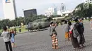 Warga berpose berlatar helikopter TNI di kawasan Monumen Nasional, Jakarta, Jumat (19/4). Libur panjang perayaan Paskah 2019 dimanfaatkan warga untuk berwisata di kawasan Monumen Nasional. (Liputan6.com/Helmi Fithriansyah)