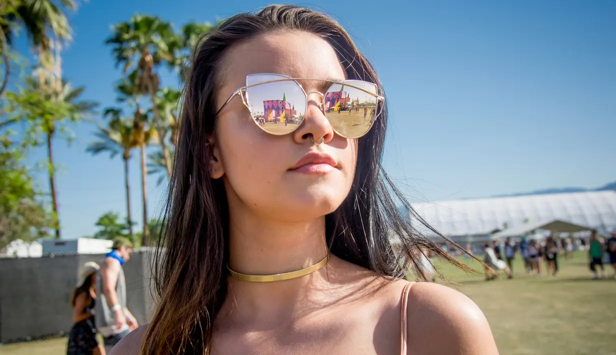 Olivia Guerrieri berpose menggunakan kaca mata saat menghadiri Coachella Music & Arts Festival di Empire Polo Club di Indio, California (15/4). Festival Coachella ini sudah ada sejak 1999. (Photo by Amy Harris/Invision/AP)