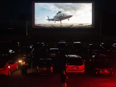 Puluhan mobil terparkir di depan layar bioskop saat pemutaran film drive-in di Family Drive-in di Virginia, 10 Agustus 2018. Menonton film di luar ruangan atau drive-in merupakan bagian penting dalam industri hiburan di Amerika. (AFP PHOTO/Nicholas Kamm)