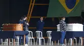 Kerabat korban kecelakaan pesawat Voepass berduka di samping peti mati mereka dalam sebuah misa di pangkalan udara Sao Paulo di Guarulhos, Brasil, Selasa (13/8/2024). (Miguel SCHINCARIOL / AFP)