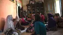 Kerabat Letnan Satu Muhammad Imam Adi yang bertugas dalam kapal selam KRI Nanggala 402 berkumpul di rumah keluarga di Pasuruan, Jawa Timur, Minggu (25/4/2021). KRI Nanggala 402 hilang kontak di lepas pantai Bali pada 21 April dan kemudian dinyatakan tenggelam dengan 53 awak. (Juni Kriswanto/AFP)
