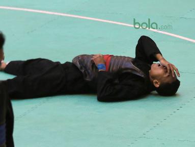 Arafa M. Yachser jatuh setelah wajahnya terkena pukulan pesilat Malaysia, Shukor M. Z. Hakim pada semifinal putra kelas 55 kg - 60 kg Test Event Pencak Silat 2018 di Padepokan Silat TMII, Jakarta, (12/2/2018). Arafa menang 5-0. (Bola.com/Nick Hanoatubun)