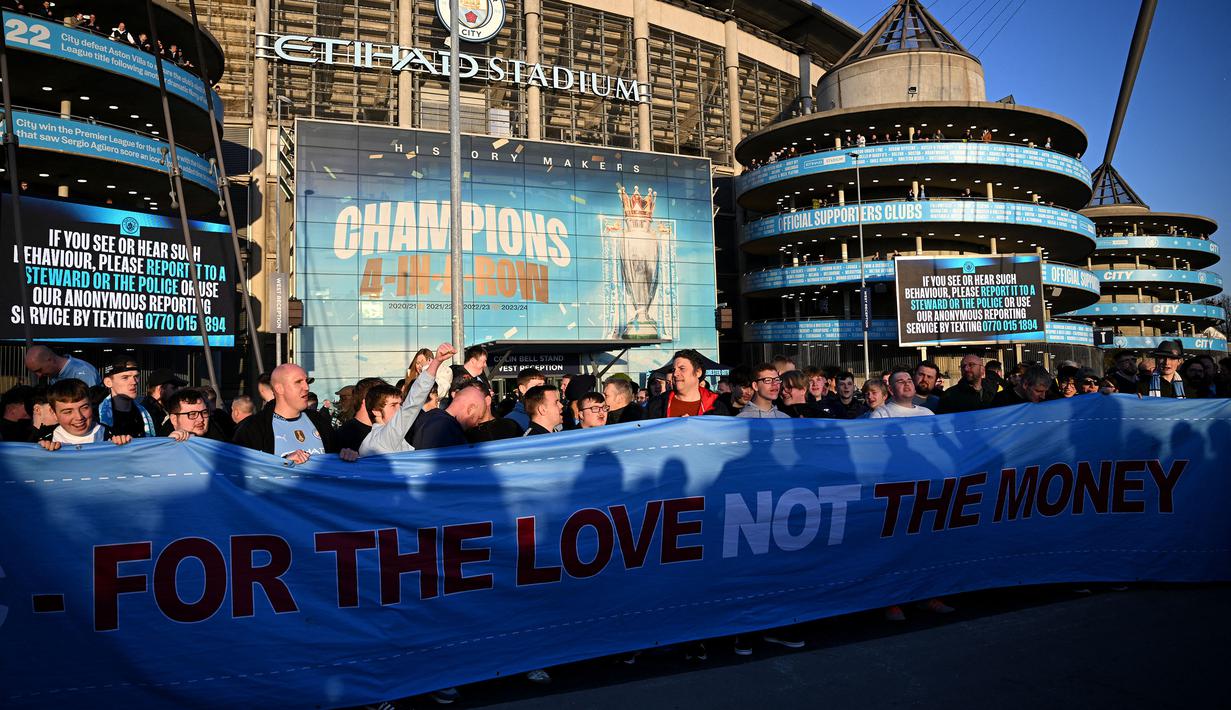 Para pendukung Manchester City melakukan protes akibat mahalnya harga tiket dengan membentangkan banner bertuliskan "MFC untuk cinta bukan uang"  sebelum laga lanjutan Liga Inggris 2024/2025 melawan Leicester di Etihad Stadium, Manchester, Inggris, Rabu (02/04/2025) waktu setempat. (AFP/Oli Scarff)