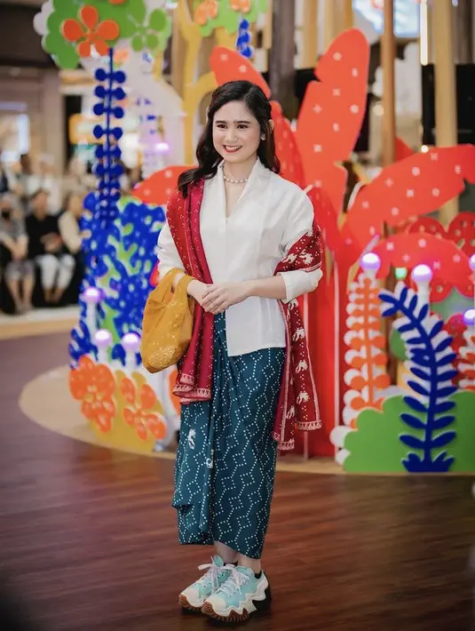 Tissa Biani tampil mengenakan kebaya putih dipadukan dengan kain hijau yang serasi dengan sneakes Conversenya. [Instagram/@tissabiani]