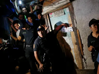 Petugas berjaga di luar rumah yang dikenal sebagai sarang peredaran obat-obatan terlarang di Manila, Filipina, (1/11).  Menurut keterangan polisi dan saksi mata, terdapat lima orang yang tewas ditembak oleh orang tak dikenal. (REUTERS/Damir Sagolj)