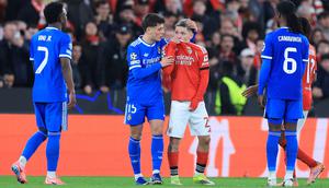 Kylian Mbappe menilai winger Benfica, Gianluca Prestianni, tidak pantas lagi tampil di kompetisi elite Eropa tersebut setelah dugaan tindakan pelecehan rasial terhadap Vinicius. Meskipun begitu Prestianni tidak mendapat kartu kuning atau merah dari wasit. Ia terlihat menutup mulutnya dengan jersey, sehingga wasit tidak menemukan bukti verba. (AFP/Patricia De Melo Moreira)