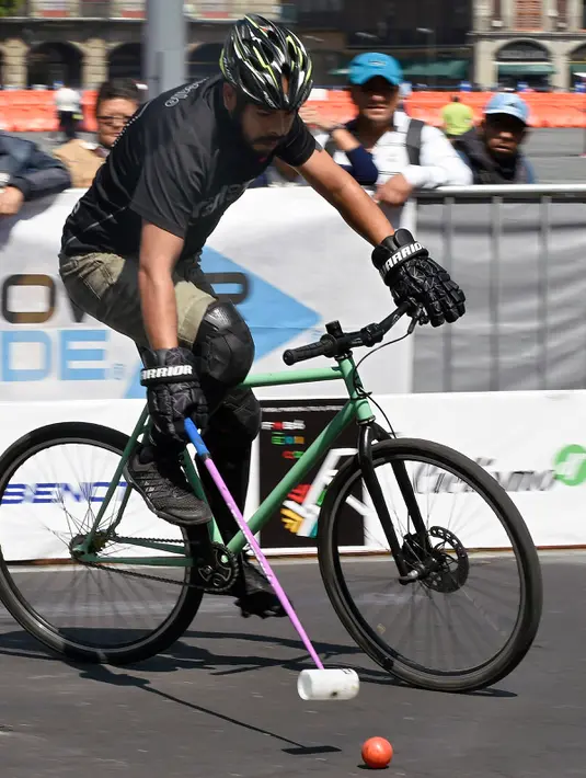 Seorang pria memacu sepedanya saat bermain Polo-Bike pada hari kedua World Bike Forum 2017 di Zocalo Square di Mexico City (20/4). (AFP Photo/Alfredo Estrella)