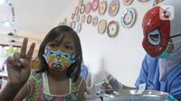 Seorang anak disuntik vaksin covid-19 oleh tenaga kesehatan bertopeng superhero saat vaksinasi anak usia 6-11 tahun di RSIA Tambak, Jakarta, Rabu (22/12/2021). Sebanyak 30 anak mengikuti vaksinasi yang menggunakan vaksin Sinovac tersebut. (Liputan6.com/Herman Zakharia)
