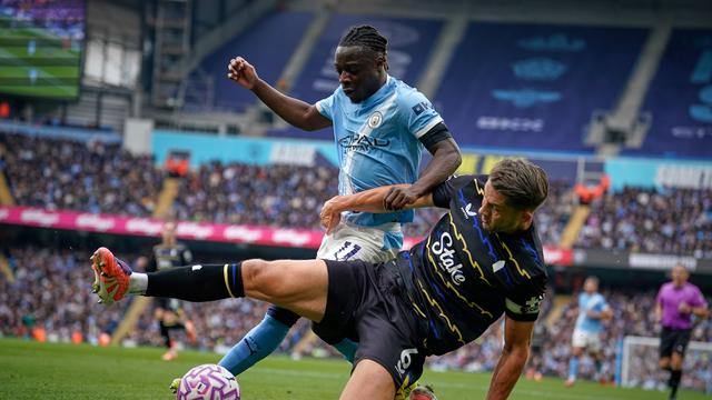 Jeremy Doku berebut bola dengan James Tarkowski di laga Manchester City vs Everton di pekan ke delapan Premier League 2025/2026 di Etihad Stadium, Sabtu (18/10/2025) malam WIB. (AP Photo/Dave Thompson)
