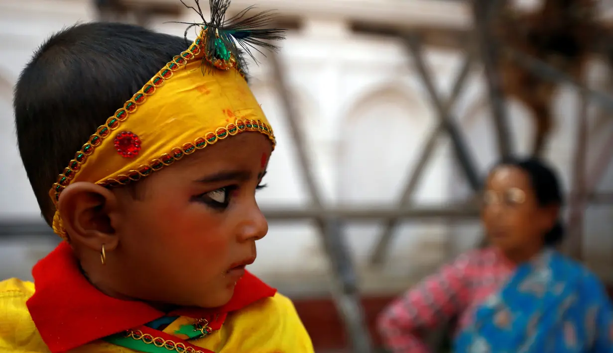 Seorang bocah berhias ala Dewa Krishna di perayaan Gaijatra Festival atau Festival Sapi di Kathmandu, Nepal, Jumat (19/8). Festival ini digelar untuk meminta keselamatan dan kedamaian. (REUTERS/ Navesh Chitrakar)