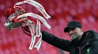 Ekspresi bahagia pelatih Liverpool, Jurgen Klopp saat mengangkat trofi Carabao Cup 2023/2024 di Stadion Wembley, Inggris, Minggu (25/02/2024). The Reds menang atas Chelsea dengan skor 1-0 melalui gol Virgil Van Dijk pada menit ke-118. (AFP/Adrian Dennis)