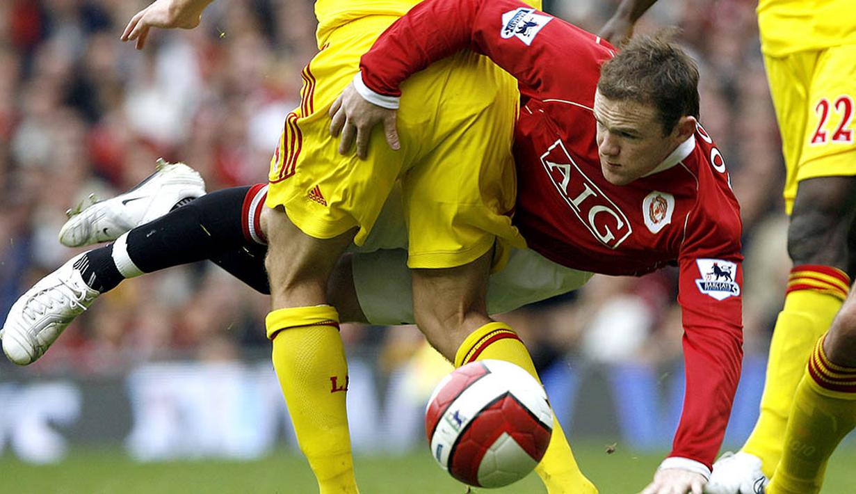 Penyerang Manchester United, Wayne Rooney terjatuh saat berebut bola dengan gelandang Liverpool, Xabi Alonso, pada laga Liga Premier Inggris di Stadion Old Trafford, Inggris, Minggu (22/10/2006). (AFP/Andrew Yates)
