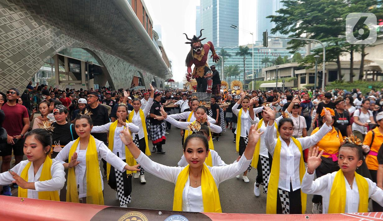 Sejumlah penari saat mengarak ogoh-ogoh saat hari bebas berkendara di kawasan Bundaran HI, Jakarta, Minggu (12/3/2023). Kegiatan ini diharapkan bisa menjadi simbol kerukunan antar umat beragama di Jakarta. (Liputan6.com/Angga Yuniar)