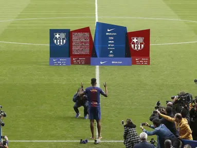 Pemain baru Barcelona asal Kolombia, Yerry Mina mengangkat tangan sebagai ucapan syukur saat tiba di Camp Nou stadium, Barcelona, (13/1/2018). Mina melepas sepatu saat menginjak rumput Stadion. (AP/Manu Fernandez)
