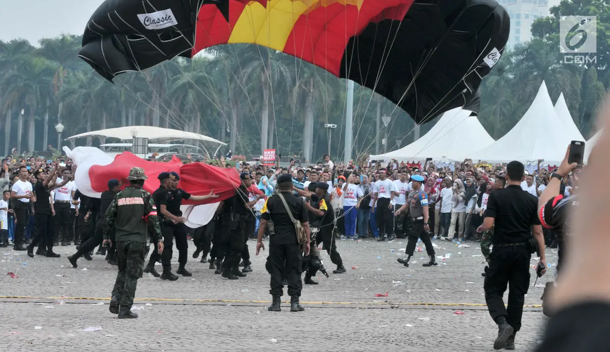 Penerjun payung mendarat saat Festival Damai Millenial Road Safety di Monas, Jakarta, Minggu (23/6/2019). Aksi ini diikuti puluhan penerjun payung dari personel gabungan TNI-Polri. (merdeka.com/Iqbal Nugroho)