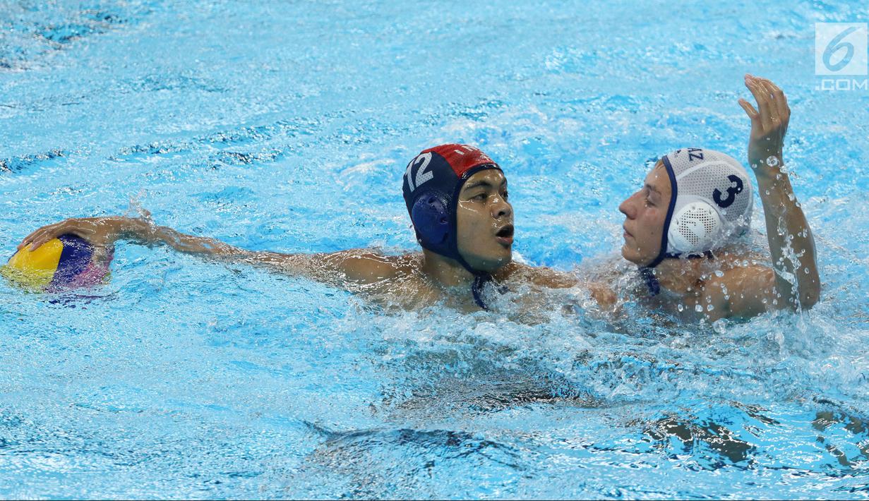 Pemain Polo Air Putra Indonesia, Zaenal Arifin (kiri) mencoba mengecoh Ruslan Akhmetov (Kazakhstan) pada perempat final Polo Air Putra Asian Games 2018, Stadion Akuatik GBK Jakarta, Kamis (30/8). Indonesia kalah 20-4. (Liputan6.com/Helmi Fithriansyah)