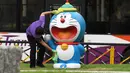 Seorang staf membersihkan dan mendisinfeksi patung Doraemon di pameran "Doraemon's Time-Travelling Adventures in Singapore" yang digelar di Museum Nasional Singapura pada 3 November 2020. Pameran ini akan berlangsung hingga 27 Desember 2020. (Xinhua/Then Chih Wey)