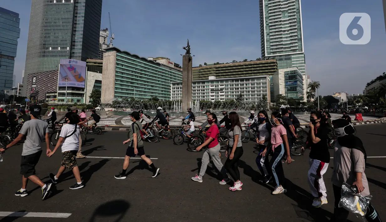 Warga berolahraga di area Car Free Day (CFD) kawasan MH Thamrin, Jakarta, Minggu (21/6/2020). Kegiatan hari bebas kendaraan bermotor atau CFD Jakarta kembali dibuka pada Minggu (21/6) ini diiringi dengan sejumlah protokol kesehatan. (Liputan6.com/Johan Tallo)