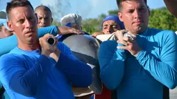 Petugas membopong lumba-lumba untuk dipindahkan ke Dolphinarium di Cienfuegos, Kuba (8/9). Sebelumnya, pada Jumat (8/9) badai Irma menguat dan mendarat di Kuba. (Osvaldo Gutierrez Gomez / ACN via AP)