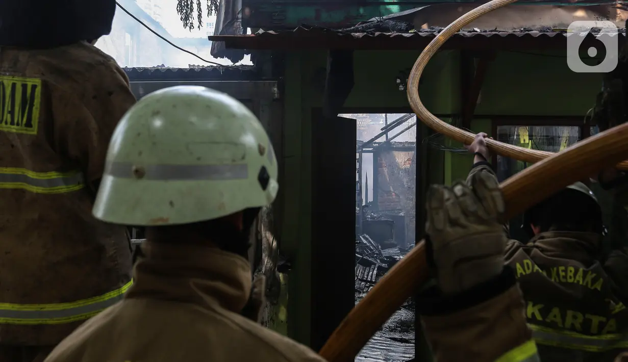 Petugas pemadam kebakaran melakukan proses pendinginan pada permukiman penduduk yang terbakar di Jalan Masjid Alhuda atau depan Stasiun Kebayoran Lama RT 05/01, Jakarta Selatan, Selasa (24/5/2022). Tidak ada korban jiwa dalam kebakaran yang menghanguskan sekitar 20 rumah tersebut. (Liputan6.com/Johan Tallo)