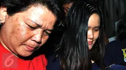 Jessica Kumala Wongso (kanan) saat di gelandang petugas Polda Metro Jaya ke ruang tahanan, Sabtu (30/1). Mukanya tampak lesu saat dibawa oleh belasan petugas menuju tahanan. (Liputan6.com/JohanTallo)