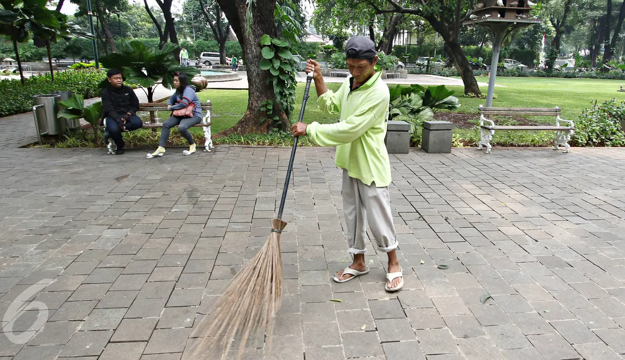 Pekerja Harian Lepas (PHL) sedang menyapu di Taman Suropati, Jakarta, Senin (18/1/2016). Pemprov DKI Jakarta akan mengaudit Dinas Kebersihan terkait kejanggalan antara jumlah PHL dengan penganggaran. (Liputan6.com/Immanuel Antonius)