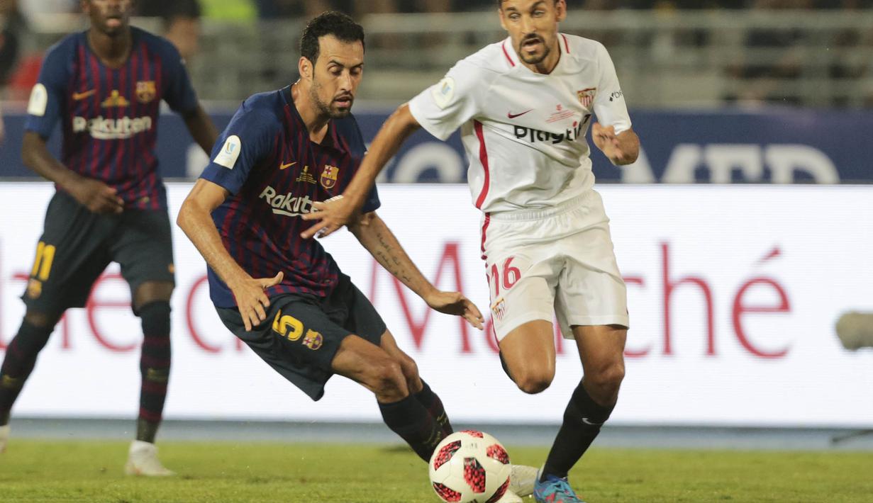 Gelandang Sevilla, Jesus Navas, berebut bola dengan gelandang Barcelona, Sergio Busquets, pada laga Piala Super Spanyol di Stadion Ibn Batouta, Tangiers, Minggu (12/8/2018). Barcelona menang 2-1 atas Sevilla. (AP/Mosa'ab Elshamy)