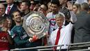 Pelatih Arsenal, Arsene Wenger, bersama kiper Petr Cech, mengangkat trofi Community Shield usai mengalahkan Chelsea di Stadion Wembley, London, Minggu (6/8/2017). Ini merupakan trofi Community Shield yang ke-15 bagi Arsenal. (AFP/Ian Kington)