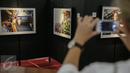 Pengunjung memotret karya foto yang dipajang pada pameran foto jurnalistik Setahun Kerja Jokowi-JK di Museum Bank Mandiri, Jakarta, Jumat (18/12). Pameran itu mengangkat berbagai kegiatan Kabinet Kerja selama setahun. (Liputan6.com/Faizal Fanani)