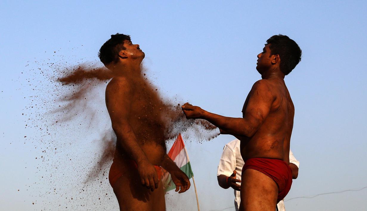 Pegulat melumuri tubuh dengan tanah sebelum berlaga Indian traditional wrestling competition atau Kushti di Arena Akhara, Mumbai, 20 Maret 2016. Olahraga tradisional ini terus dilestarikan sebagai bagian dari budaya. (EPA/Divyakant Solanki)