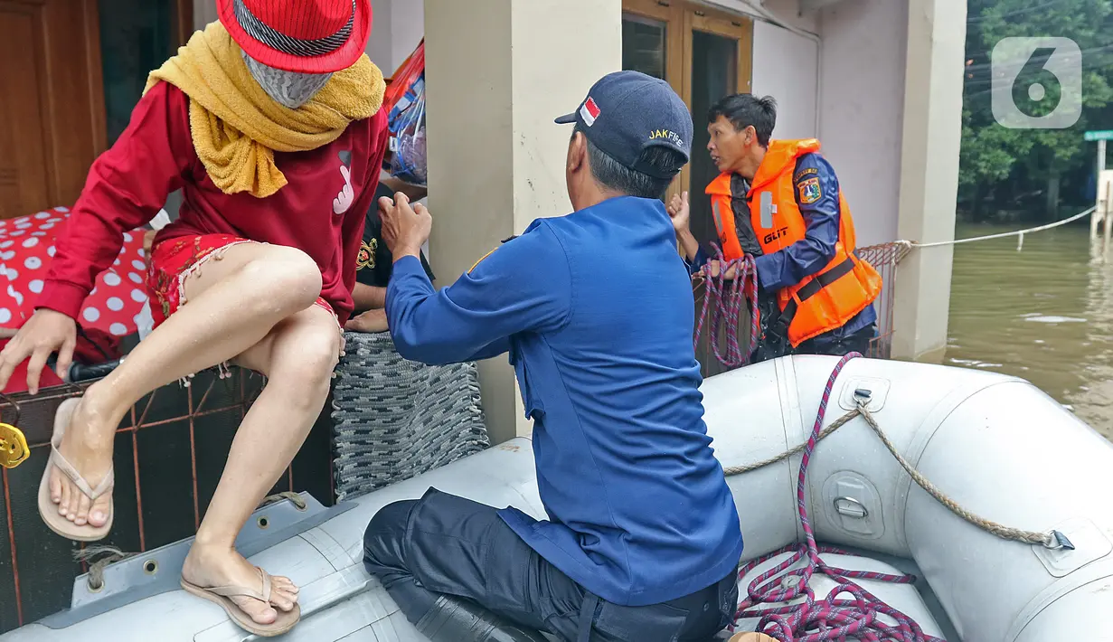 Petugas mengevakuasi warga yang terjebak banjir di RW 07, Kelurahan Pekayon, Jakarta Timur, Sabtu (20/2/2021). Banjir di kawasan tersebut terjadi akibat curah hujan yang tinggi. (Liputan6.com/Herman Zakharia)