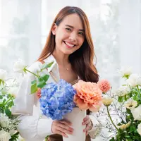 ilustrasi perempuan memegang bunga/WHYFRAME/Shutterstock