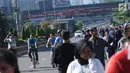 Warga berjalan di kawasan Jalan Jenderal Sudirman, Jakarta, Minggu (31/12). Meski Hari Bebas Kendaraan dipenghujung 2017 ditiadakan, warga tetap memadati kawasan sekitar Jalan Jend Sudirman dan MH Thamtin, Jakarta. (Liputan6.com/Helmi Fithriansyah)