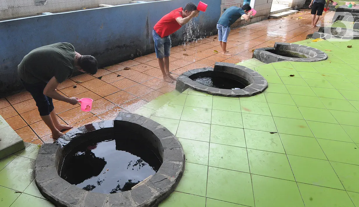 Warga melakukan ritual mandi usai bersembahyang pada perayaan Tahun Baru Imlek 2571 di Vihara Gayatri, Depok, Sabtu (25/1/2020). Pada perayaan Imlek, banyak yang mandi atau sekedar cuci muka, tangan dan kaki di 7 sumur yang dipercaya memiliki keistimewaan tersebut. (merdeka.com/Arie Basuki)