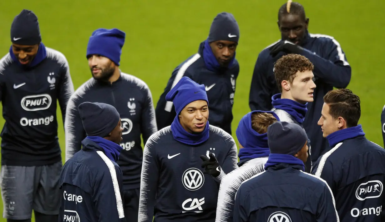 Striker Prancis, Kylian Mbappe, berbincang dengan rekannya saat mengikuti sesi latihan di Stade De France, Paris, Minggu (19/11/2018). Prancis akan mejalani laga persahabatan melawan Uruguay. (AP/Francois Mori)