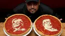 Chief Cook, Fabian Martinez berpose dengan pizza bergambar wajah calon presiden AS dari Partai Republik, Donald Trump dan rivalnya dari Partai Demokrat, Hillary Clinton di Giordano Pizzeria, Chicago, Selasa (27/9). (REUTERS / Jim Young)