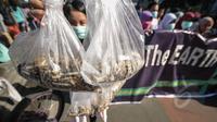 Seorang aktivis menunjukkan puntung rokok yang berhasil dikumpulkan saat Aksi Selamatkan Bumi dari Limbah Puntung Rokok di kawasan Bundaran HI, Jakarta, Minggu (26/4/2015). Kegiatan tersebut untuk memperingati Hari Bumi. (Liputan6.com/Faial Fanani)