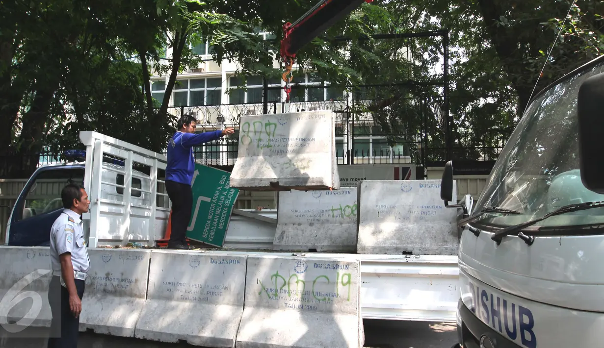 Petugas Dishub membongkar beton pembatas Jalan M. Yamin di depan bekas gedung Kedubes Inggris, Jakarta, Kamis (17/9/2015). Pembongkaran dilakukan karena beton tersebut akan dipergunakan di tempat lain. (Liputan6.com/Angga Yuniar)