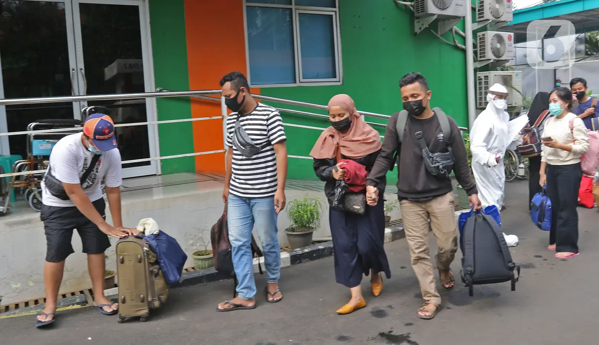 Sejumlah pasien Covid-19 berjalan memasuki bus sekolah di Puskesmas Kecamatan Ciracas, Jakarta, Kamis (10/06/2021). Kasus positif di Jakarta bertambah 2.096 orang, sehingga total kasus positif bertambah menjadi 440.554 orang. (Liputan6.com/Herman Zakharia)
